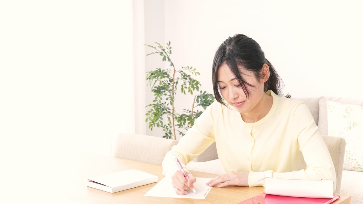 Jeune femme concentrée qui révise à son bureau avec ses notes avant un examen