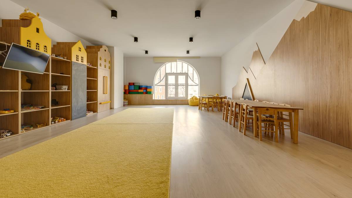 Salle de classe d'école maternelle aménagée avec tables et chaises à hauteur d'enfant