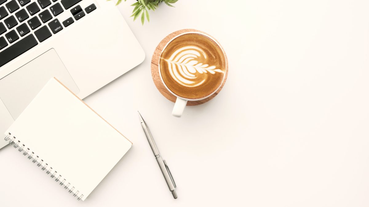 Bureau clair avec ordinateur portable, carnet et stylo, préparation d'une candidature en école d'éducateur de jeunes enfants
