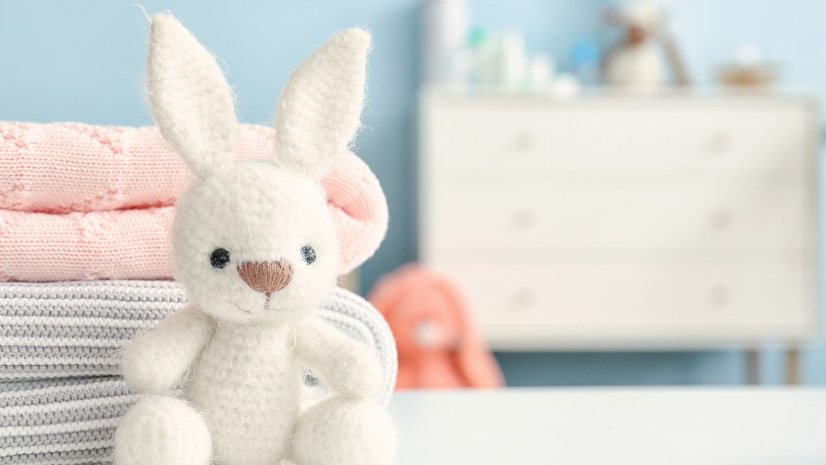 Peluche et vêtements d'enfant posés sur une table dans une chambre d'enfant