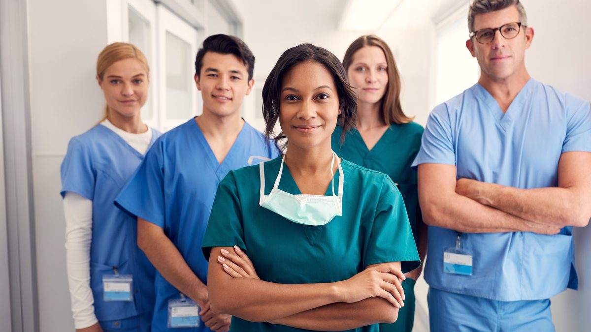 Équipe soignante en tenue professionnelle dans un couloir d'hôpital