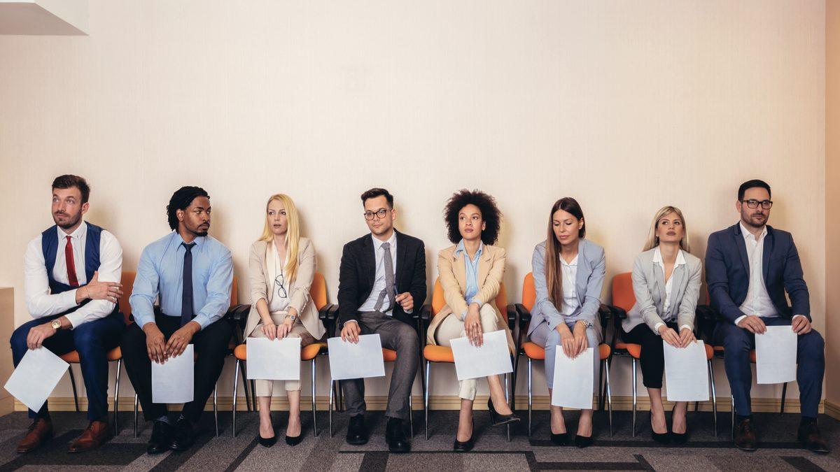 Rangée de candidats en tenue de ville attendant leur passage devant un jury