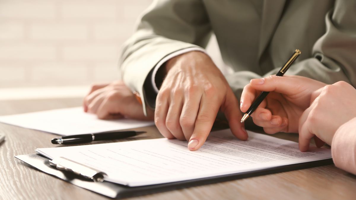 Préparation d'un dossier de candidature : mains et documents posés sur un bureau