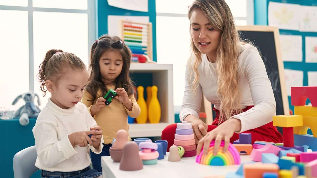 Professionnelle de la petite enfance accompagnant de jeunes enfants pendant une activité en structure d'accueil