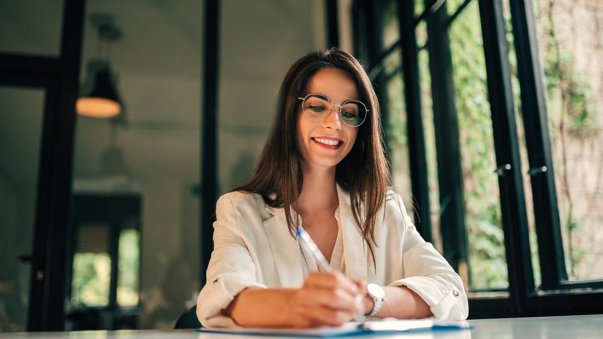 Femme rédigeant un dossier écrit à une table lumineuse