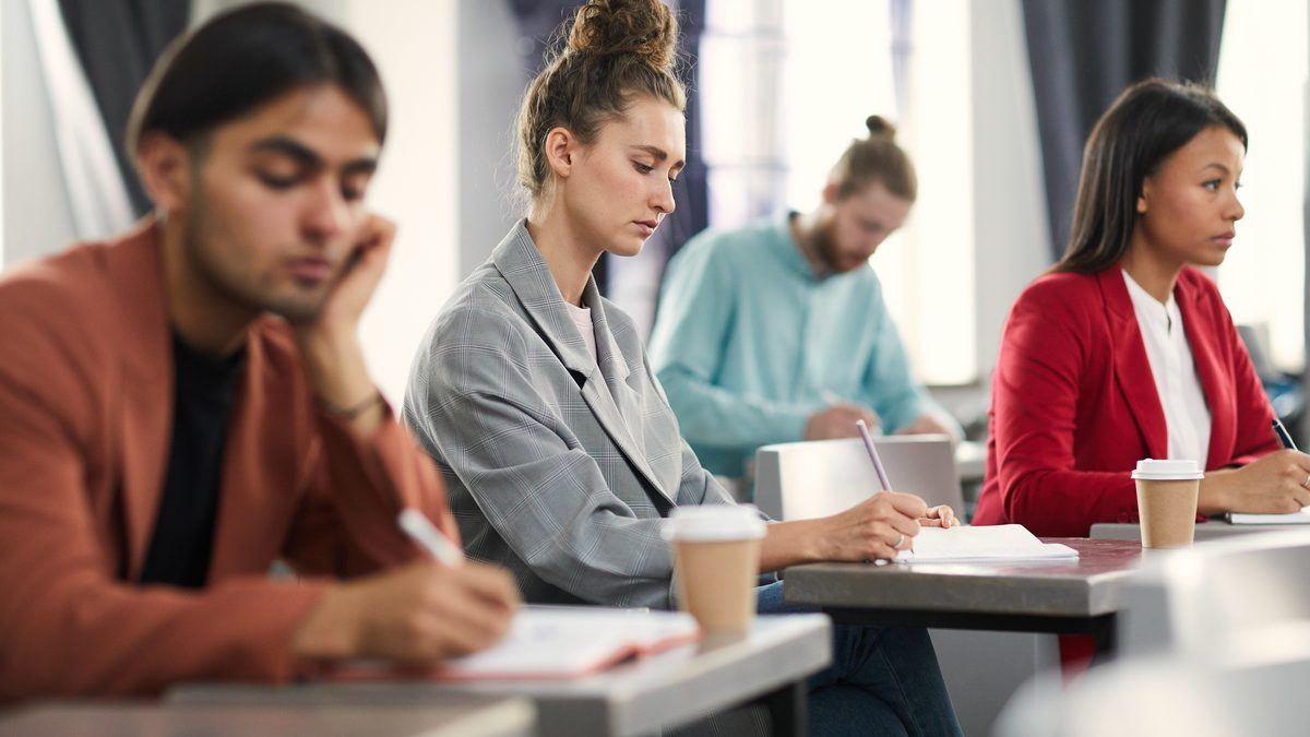 Élèves adultes en formation prenant des notes pendant un cours en institut