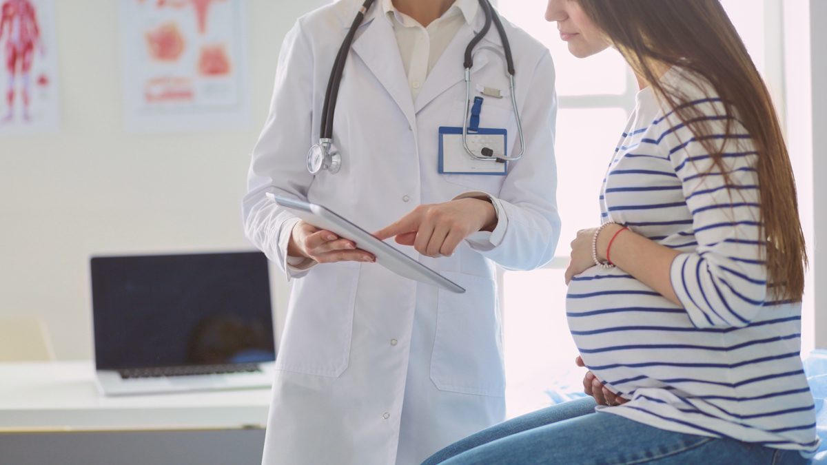 Une femme enceinte échange avec une médecin lors d'une consultation