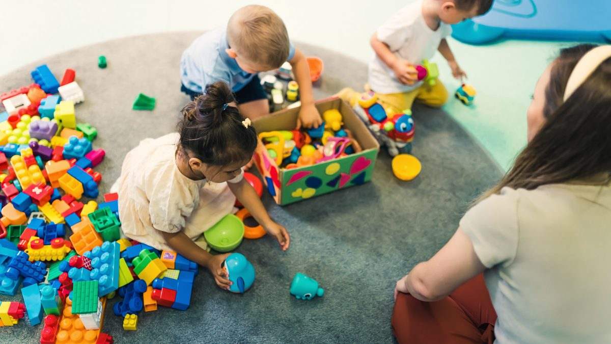 Professionnelle de la petite enfance accompagnant des tout-petits dans une salle de jeu