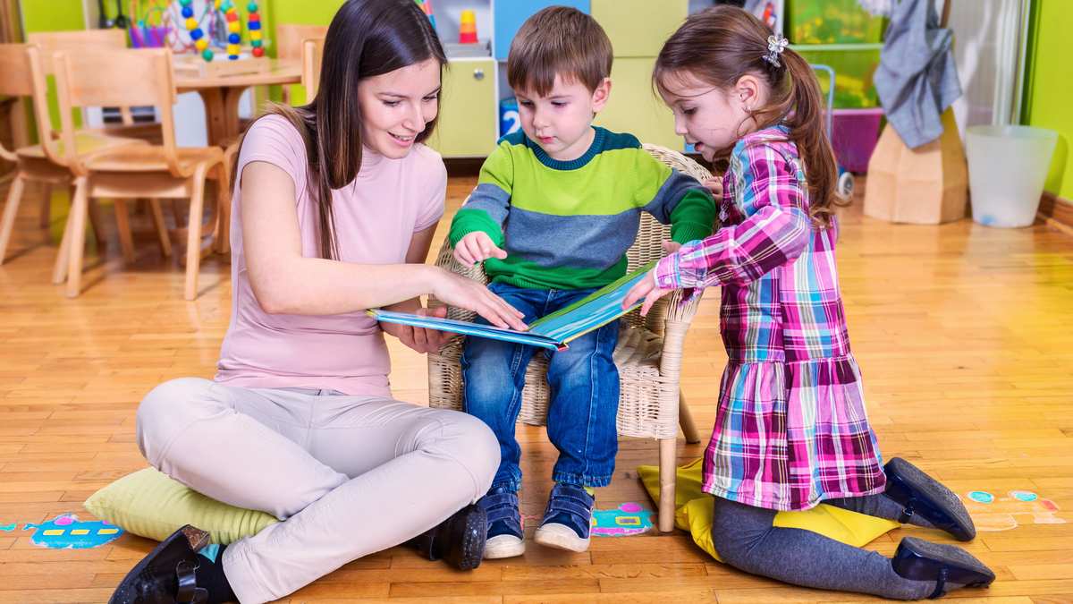 Professionnelle de la petite enfance accompagnant un jeune enfant pendant une activité d'éveil en crèche