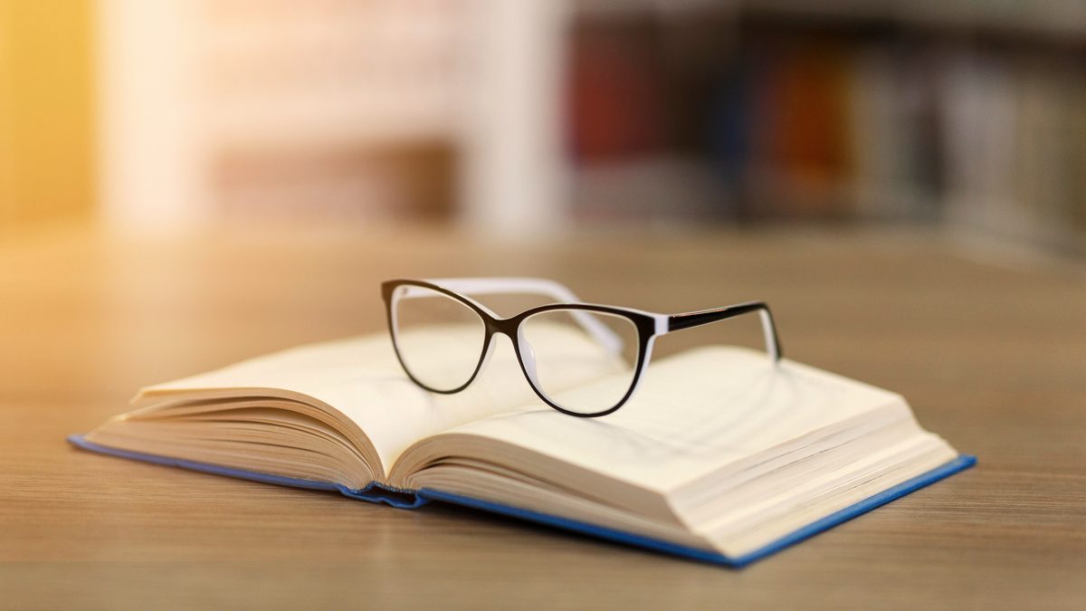 Une paire de lunettes posée sur un livre ouvert