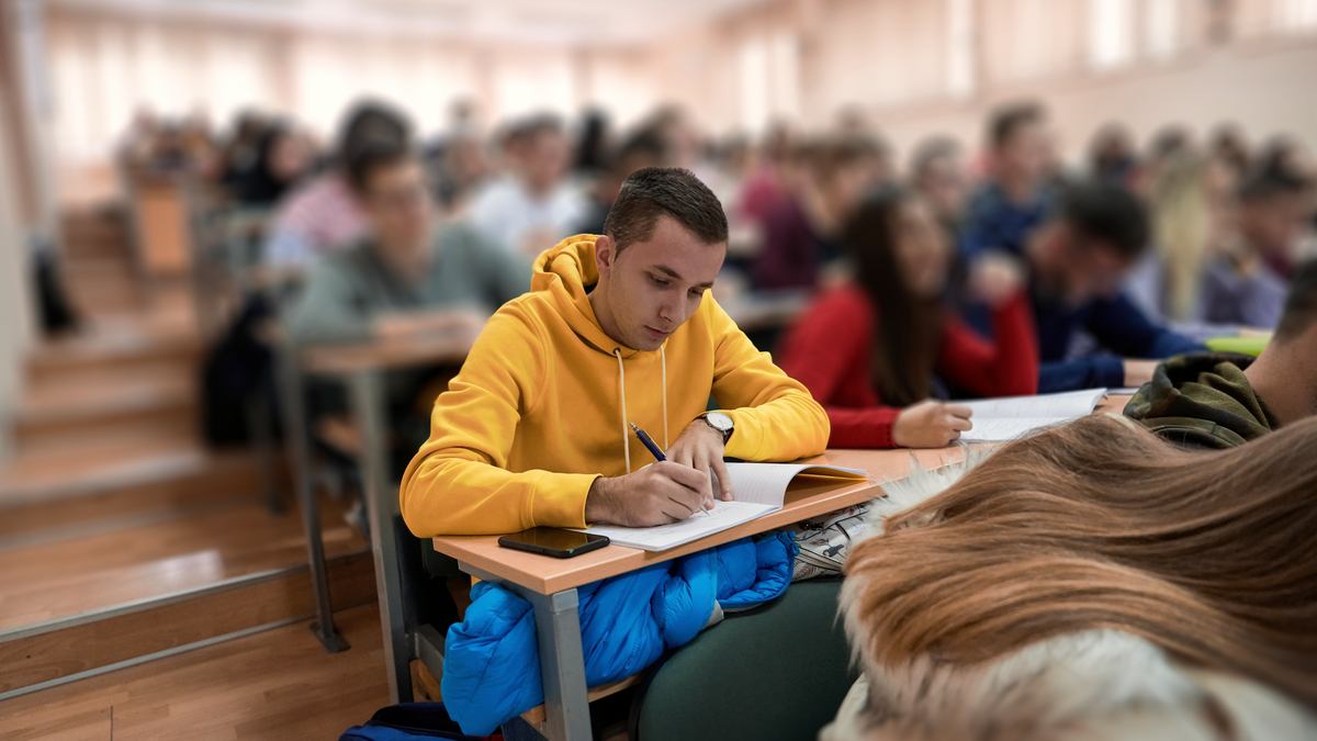 Étudiant prenant des notes en amphi, révision du programme de l'EP2 du CAP AEPE