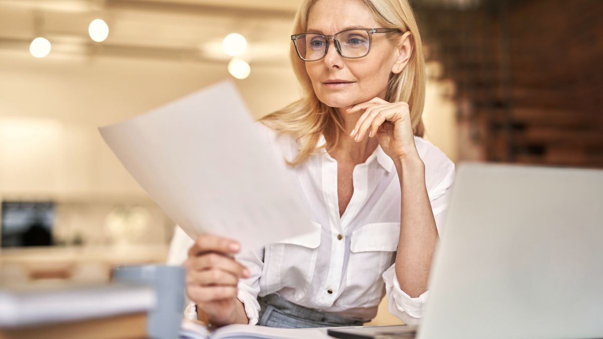 Professionnelle examinant un dossier de candidature devant son ordinateur portable
